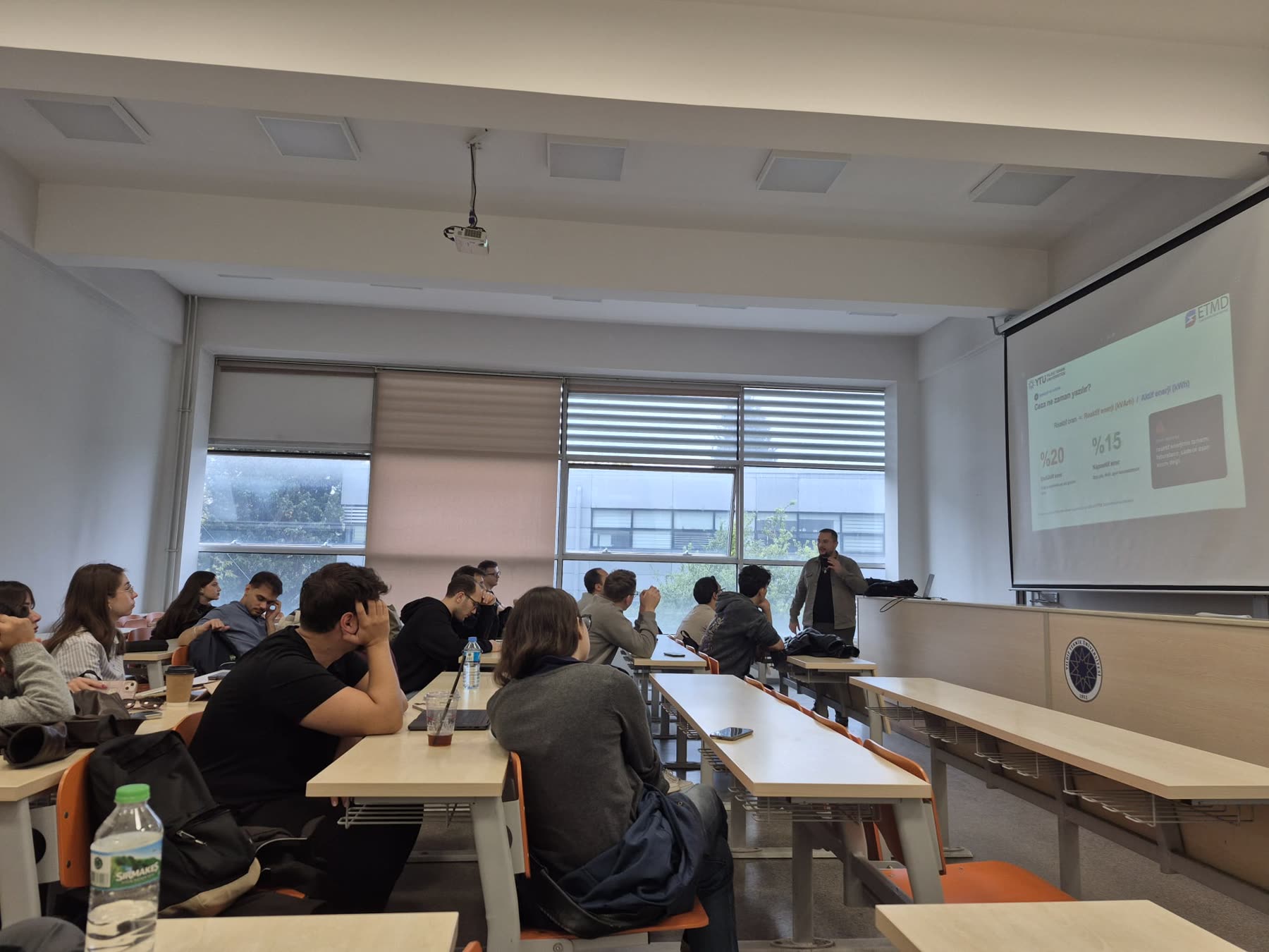 Mertcan Çakır lecturing at Yıldız Technical University, ETMD slide on screen